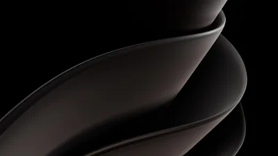 Two smooth forms curve past each other in warm grey, lit softly from the right so most of the left half stays in shadow.