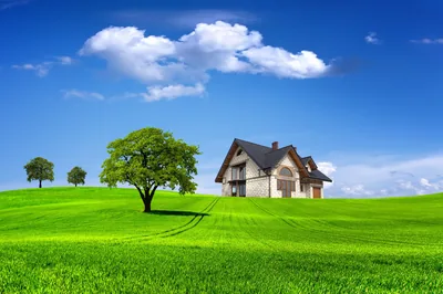 A stone cottage sits right of centre on mowed lawn under cumulus clouds; the saturated composite look reads cleanly even on a small laptop screen.