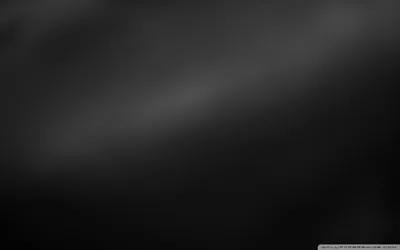 A near-featureless charcoal gradient with a faint diagonal sheen from the upper left, dark enough that desktop icons and text stay readable anywhere on it.