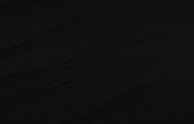 An almost flat black surface with faint diagonal grain lines running through the middle of the frame.