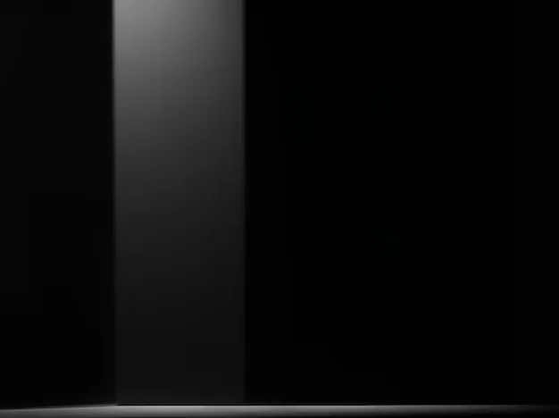 One pale grey column of light stands against a black studio wall, its reflection stopping short on the floor below.