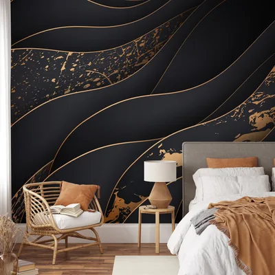 Layered black waves edged in gold flow across a bedroom wall, brightest along the top edge; a rattan chair anchors the lower left.