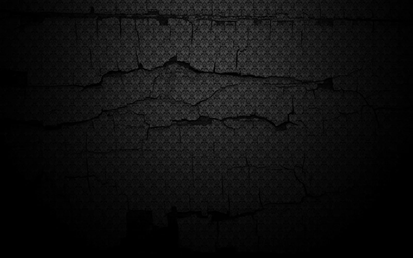 An ornate damask print sits on a black wall split by deep horizontal cracks, the plaster darkening heavily toward every corner.