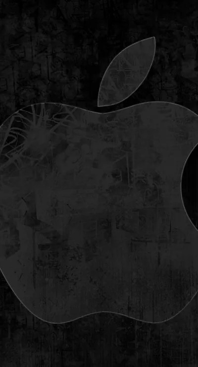 The Apple logo sits centred on a scratched, grimy dark surface, its outline visible only through the difference in wear.