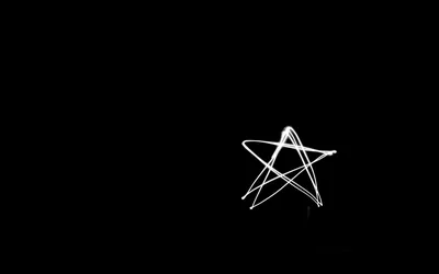 A five-pointed star sketched in thin white light-painted lines, sitting right of centre with the whole left side left empty.