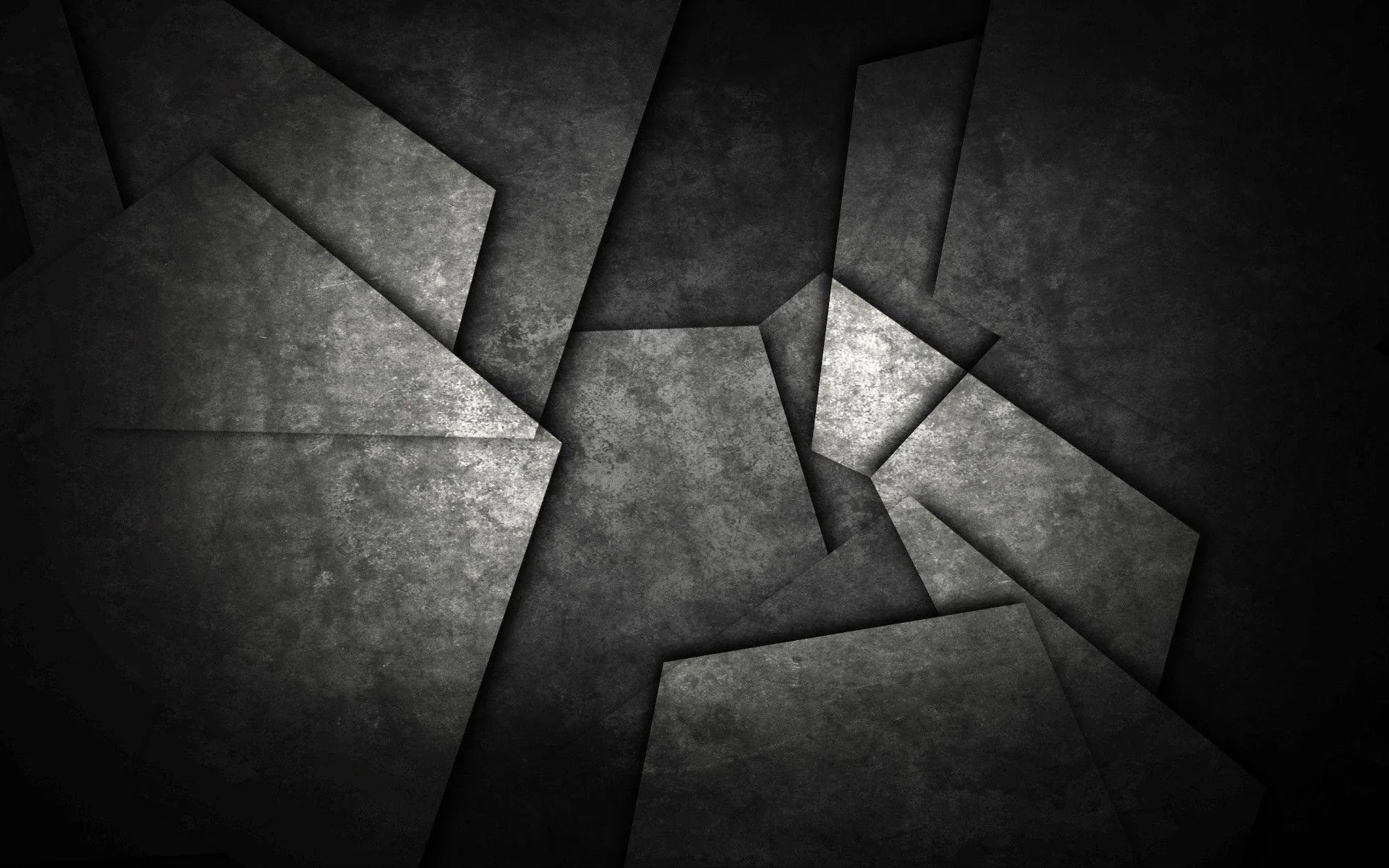 Slabs of rough concrete split apart across the frame, the edges catching light while the gaps stay in shadow.