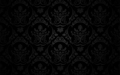 A symmetrical crest and scroll motif repeats in soft grey over black, the light strongest across the middle rows and gone by the edges.
