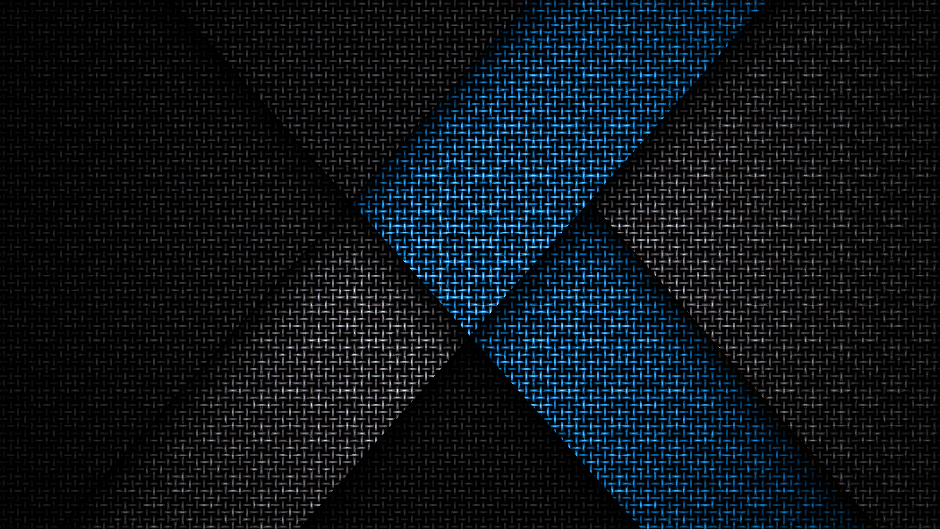 Overlapping panels of dark carbon weave cross into an X, the upper wedge filled with a blue perforated pattern that catches the light.