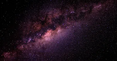 The Milky Way's dusty band cuts in from the top left, glowing pink and violet, while the lower right stays a plain star field where icons read clearly.