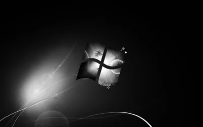 The old Windows flag ripples in monochrome against black, a lens flare coming in low from the left.