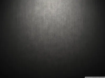 A brushed grey backdrop lit from above, the beam widening down the centre while the lower corners fall away to near black.