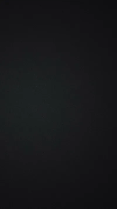 Almost flat black across the whole frame, a barely visible grain and a slight lift in the centre — the kind of plain backdrop that suits OLED screens.
