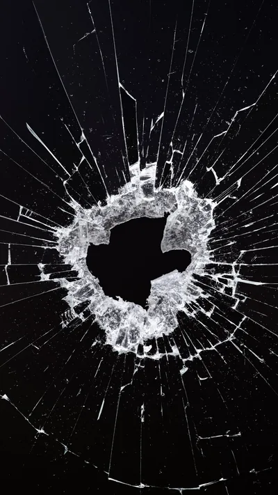 A ragged hole punched through glass, cracks running out to every corner and the fractured ring glowing white against black.