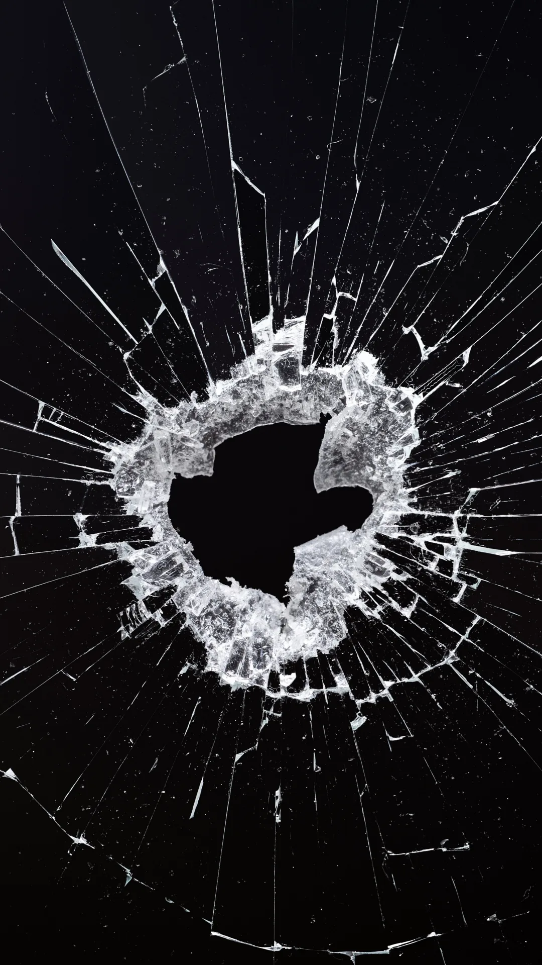 A ragged hole punched through glass, cracks running out to every corner and the fractured ring glowing white against black.