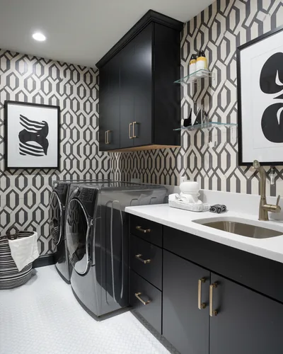 Black cabinets and a chrome washer pair with a black-and-white trellis print on the walls of a compact laundry room.