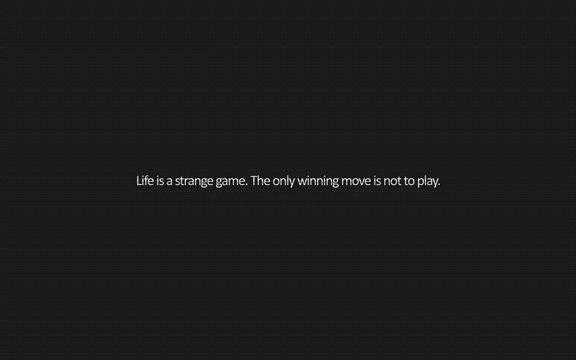 One line of small white type sits alone in the middle of a flat charcoal field: life is a strange game, the only winning move is not to play.