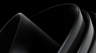 Polished black surfaces fold over one another, catching a single light source along each ridge.