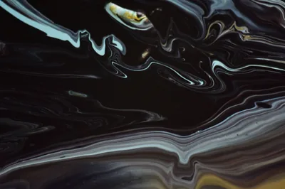 Poured black and silver paint folds into itself in long horizontal ribbons, one thread of gold running through the top.