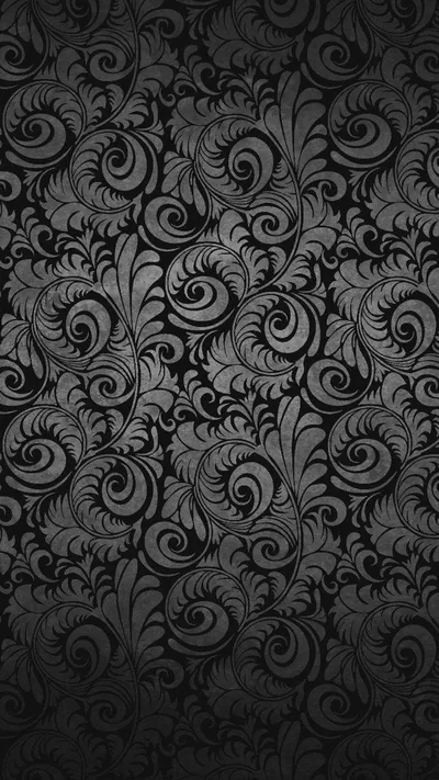 A dense damask of curling leaves and scrolls repeats edge to edge in charcoal on black — closer to texture than picture at arm's length.