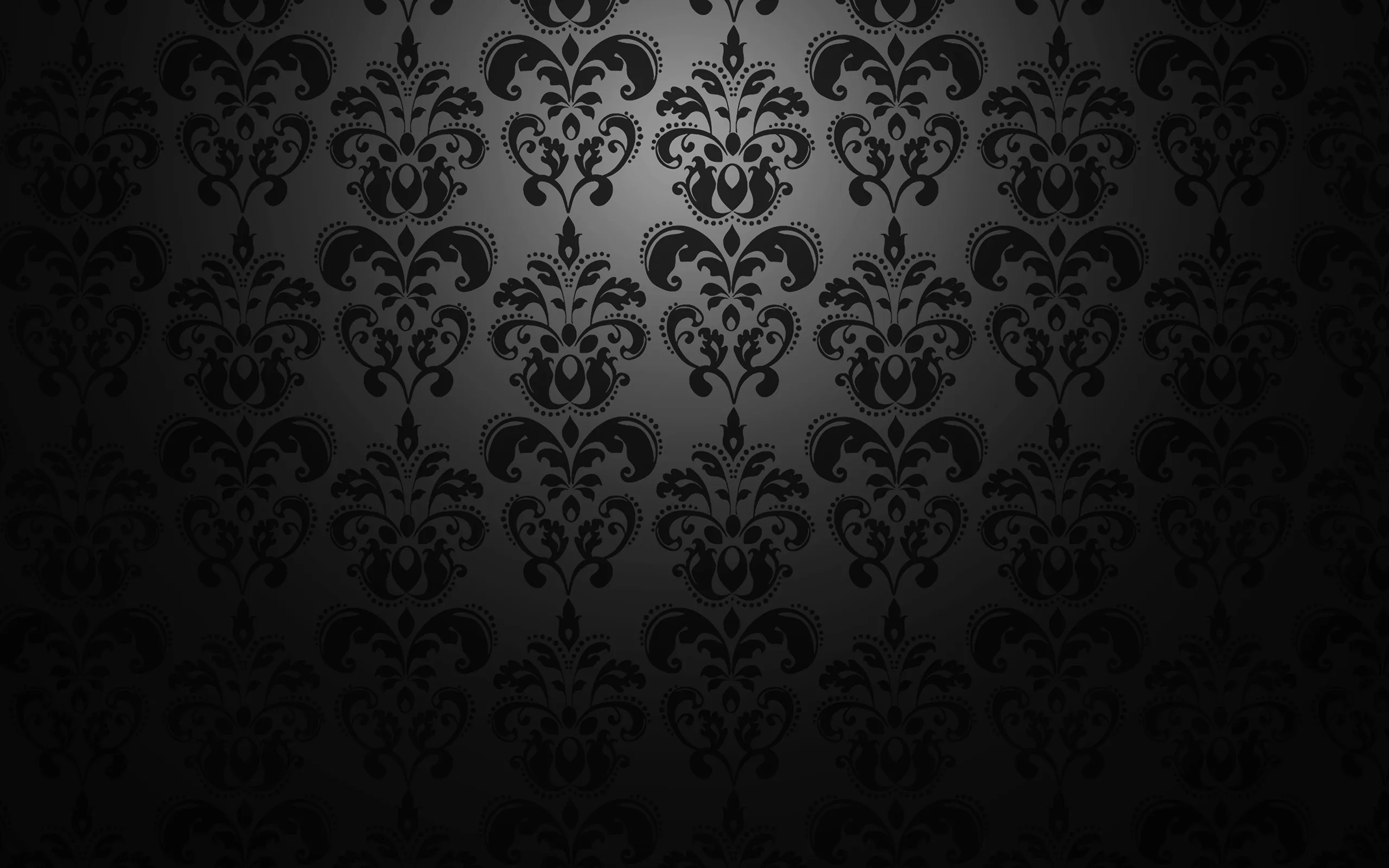 Large crowned damask motifs run in vertical columns over black, the pattern silvered through the upper middle and dropping to nothing along the bottom.