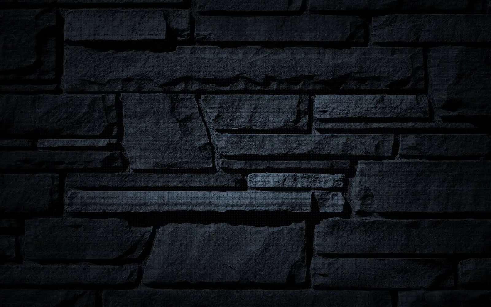Irregular stone slabs stacked in uneven courses, lit softly from the upper left with the corners dropped into shadow.