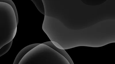 Soft overlapping bubbles in charcoal and grey drift across black — the stock iOS 13 dark look.