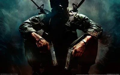 A soldier in helmet and combat webbing stands head-down with a pistol in each hand, rifles crossed behind him and green smoke curling in the dark.