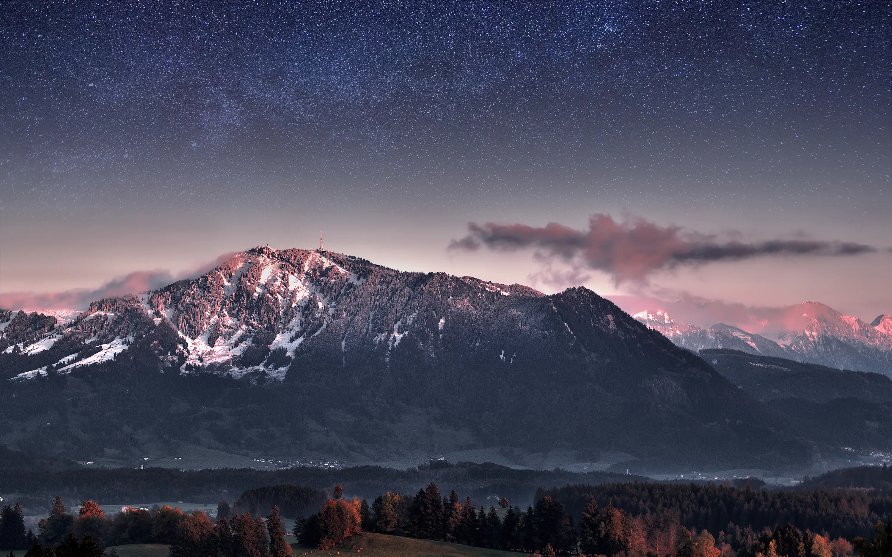 Stars fill a violet sky above a Bavarian massif still touched by pink dusk light, thin fog and dark autumn woods keeping the valley floor quiet.