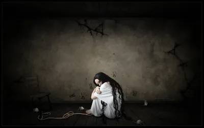 Gothic scene of a long-haired woman in a white gown sitting on the floor of a cracked grey room, a coiled rope beside her and black vignette edges.