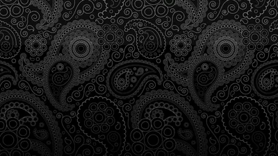 Paisley shapes and small medallions tile the whole frame in black on black, readable only by their raised edges.