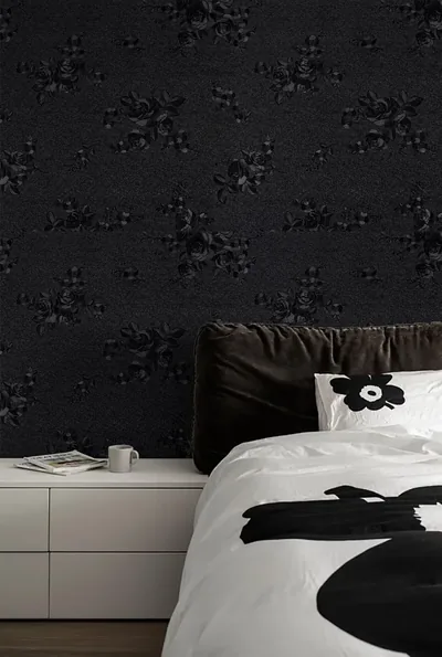 Rose sprigs embossed tone-on-tone into charcoal-black wallpaper beside a white dresser, its top left corner open for widgets on a phone crop.