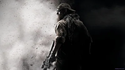 A soldier in a bandana and gear stands with his back turned as dust and smoke blow past, the scene rendered in gritty monochrome.