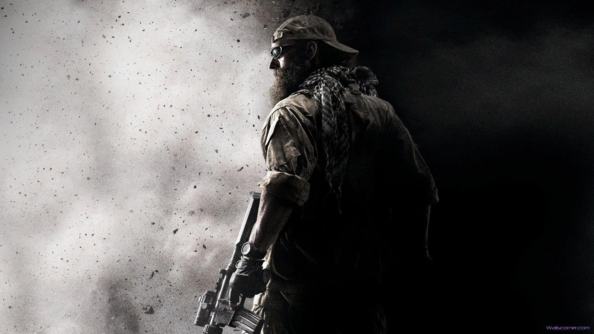 A soldier in a bandana and gear stands with his back turned as dust and smoke blow past, the scene rendered in gritty monochrome.