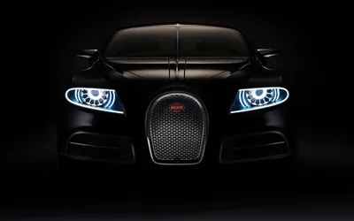 Only the nose of the coupe emerges from the dark, twin rings of cold blue light either side of a horseshoe grille and the rest left in black.