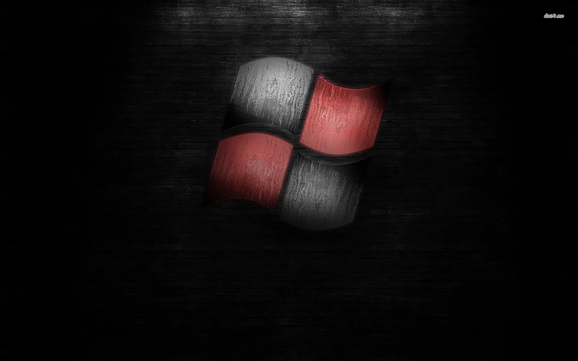 The four-pane mark sits large on a scratched dark wall, two panes red and two brushed grey.