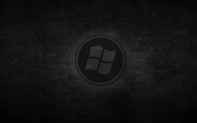 A circular window emblem sits at the centre of an unlit brick wall, a soft glow behind it lifting the middle.