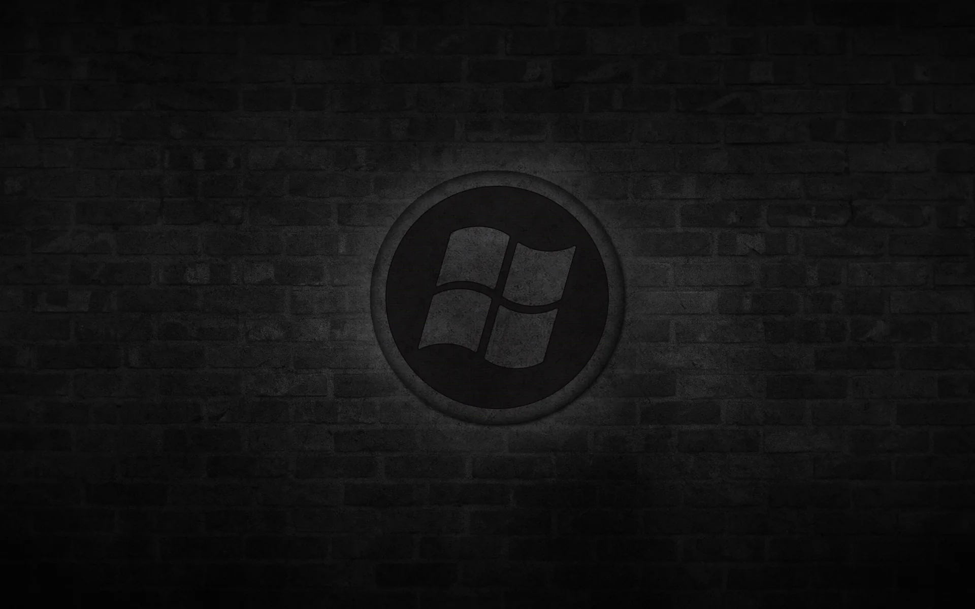 A circular window emblem sits at the centre of an unlit brick wall, a soft glow behind it lifting the middle.