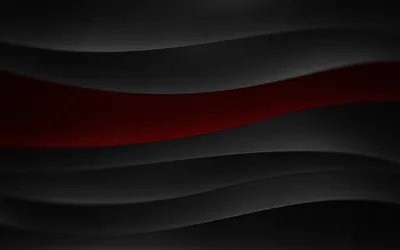 Soft black waves stack down the frame with a single red band showing through near the top, the ridges lit from the left.