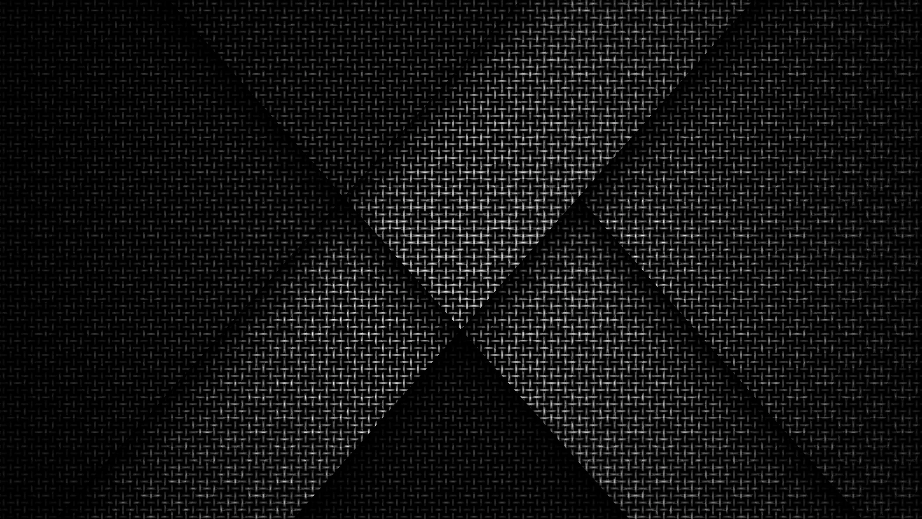 Diagonal panels of woven carbon texture cross at the centre, each plane sitting at a slightly different depth.