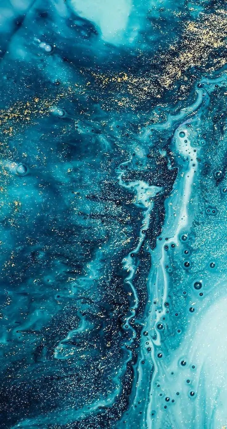 A foamy white current cuts down through layered turquoise ink, with bands of gold glitter along the upper left and small dark bubbles on the right.