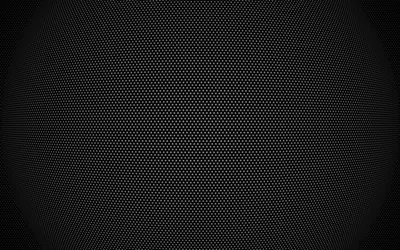 An even field of tiny holes covers a dark metal sheet, brightest through the middle band and dimming toward all four corners.