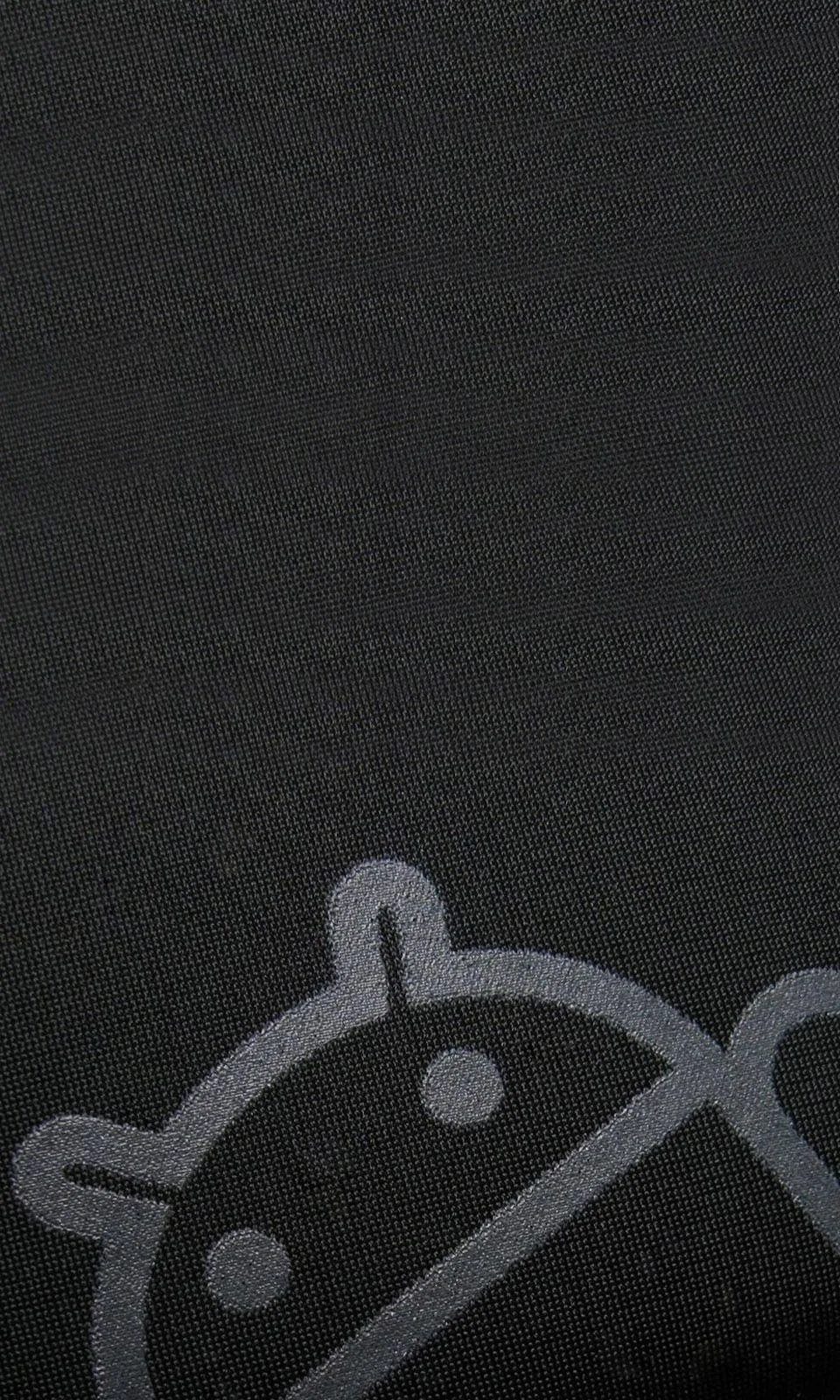 An oversized Android robot sits low in the frame, printed in slightly lighter grey on a woven charcoal cloth so the weave shows through the shape.