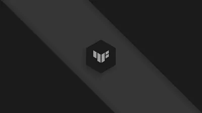 The TUF cube emblem sits small at the centre of a charcoal field, a single lighter diagonal band running behind it.