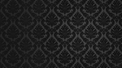 A repeating baroque damask motif pressed into charcoal fabric, the pattern only visible where light grazes the raised edges.