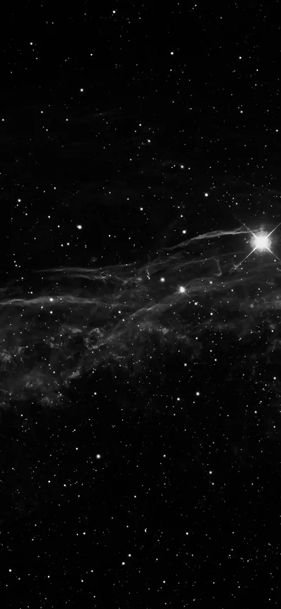 Thin threads of grey gas stretch across the middle of this tall frame, a single bright star flaring just right of centre.