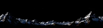 A jagged ridgeline runs the full width of an ultrawide frame, moonlight on the snow the only thing separating rock from the black sky above.