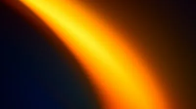 A broad amber arc sweeps from the top edge down through the left of frame, blurring softly into a navy-black field that keeps the right third empty.