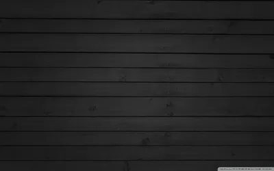 Wide planks run edge to edge in charcoal grey, grain and knots showing where the light crosses the middle rows.