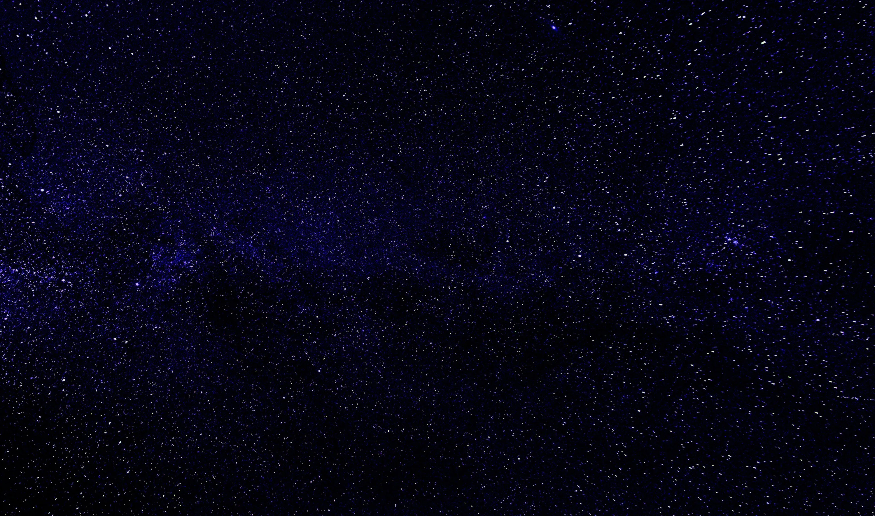A very dark navy field where a slightly brighter band of stars runs across the middle, dim enough to leave room for icons anywhere.