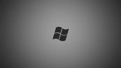 The four-pane Windows flag sits small and dark at the centre of a soft grey radial gradient, edges dimming toward the corners.